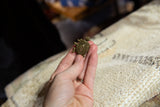 Vintage African bronze turtle pendant held in hand to demonstrate its small size.