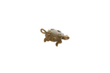 Vintage African bronze turtle pendant with raised spiral patterns on its shell.
