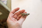 Vintage African bronze turtle pendant held in hand to show scale.