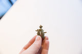Profile view of the vintage African turtle pendant showing its oxidized latticework shell.