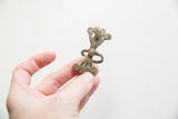 The sculptural body and imperfect band of the vintage African bronze ring viewed from the side.