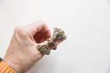 Vintage African bronze ring with peacock feathers worn on a hand for scale.