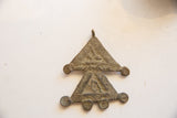Back view of vintage African bronze pendant showing its double triangle shape and spiral details.