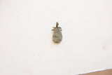 Textured reverse side of a vintage African bronze pendant with aged patina.