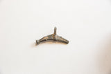 Overhead view of the vintage African bronze fish pendant showing its rustic texture and patina.