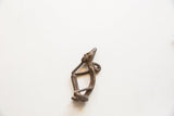 Angled view of the vintage African bronze thinking man pendant showing its form.