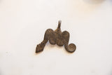 The serpentine shape and rustic, aged bronze surface of a vintage African snake pendant.