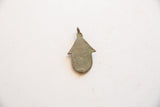 Flat reverse side of the vintage African bronze hut pendant showing its aged patina.
