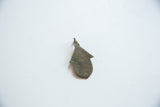 Reverse view of the African hut pendant showing its dark bronze patina.