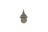 Vintage African bronze hut pendant with a textured roof and spotted design.