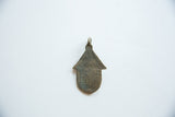 Reverse side of the bronze hut pendant, showing its unadorned surface and aged patina.