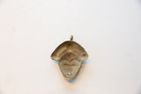 Reverse side of the vintage bronze pendant, showing its concave shape and time-worn patina.