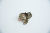 Back of vintage African bronze elephant pendant with aged patina and textured finish.