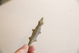 Angled view of the vintage bronze lizard's textured body and stylized head.