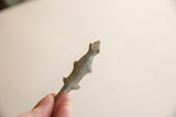 A close view of the vintage bronze lizard's textured patina and stylized form.