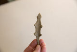 Small vintage African bronze lizard held in hand to show its scale and texture.
