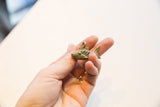 Vintage African bronze fish pendant held to show its small scale and cast details.