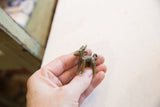 The petite form of the vintage African impala pendant resting in the palm of a hand.