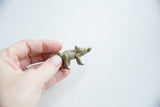 Vintage bronze boar pendant held between fingers to show its small collectible scale.