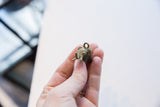 Vintage African bronze elephant pendant held between fingers to show its scale and detail.
