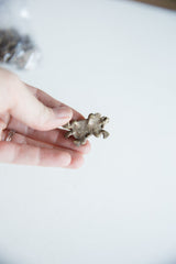 Underside view of a vintage African bronze armadillo pendant showing its coarse texture.