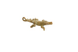 Vintage African bronze pendant shaped like a crocodile with textured scales and an aged patina.