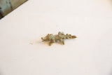 Side profile of the vintage bronze crocodile pendant showing its textured casting.