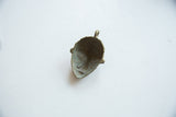 Concave interior of a vintage African bronze pendant showing its aged, textured patina.