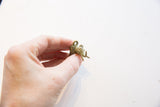 Vintage bronze elephant pendant held to show its small size and detailed oxidized texture.