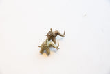 Two vintage African elephant pendants, time-softened bronze, showing openwork backs and textured legs.