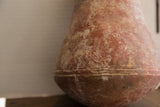 Textured, time-softened patina on the body of an antique red slip ware vase.