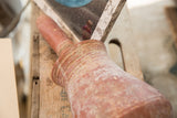 Aged surface and hand-thrown rings on the antique North African red slip ware vase.
