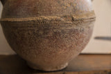 Handcrafted decorative band and time-worn earthy texture of the antique vase.