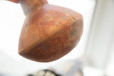 Angled view of the textured red slip ware surface on the vase's handmade base.