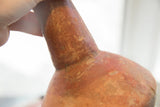Aged patina and surface texture at the neck of a red slip ware vase.