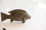 Hand-carved scales and aged patina on the profile of a vintage African fish sculpture.