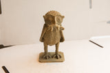 Close-up of the handmade African owl sculpture's textured head holding a rat.