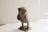 Profile view of the vintage African owl sculpture showing its aged, textured handmade finish.