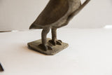 Detailed view of the vintage owl sculpture's textured talons and square metal base.