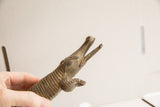 Detailed profile of the handmade crocodile sculpture's head, showing its textured scales and open jaw.