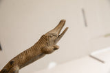 Carved details on the head and open snout of a vintage African crocodile sculpture.