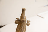 Upward view of the vintage crocodile sculpture showing its textured, hand-carved snout.