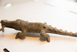 Vintage crocodile sculpture showing the detailed, carved scales along its body and tail.