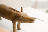 Expressive hand-modeled face of a vintage African boar sculpture showing aged texture.