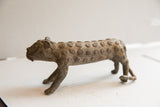 Side profile of vintage cheetah sculpture showing its textured, spiral-patterned body.