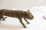 Profile view of the vintage cheetah sculpture's head showing its aged patina and raised spiral spots.