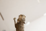 High-angle view of the vintage cheetah sculpture's textured head and patterned back.