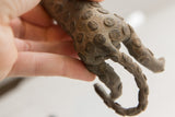 Textured spiral spots and curled tail on the vintage African cheetah sculpture.