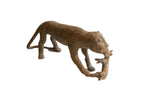 Vintage African sculpture of a cheetah with prey, showing a textured, bronze-toned patina.