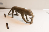 Vintage African cheetah sculpture with textured spots, carrying its prey.
